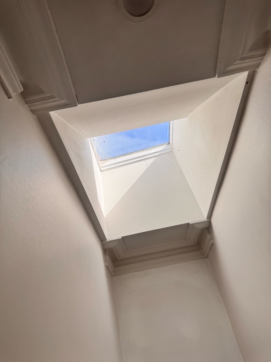 View from inside a room looking up at a skylight and natural daylight