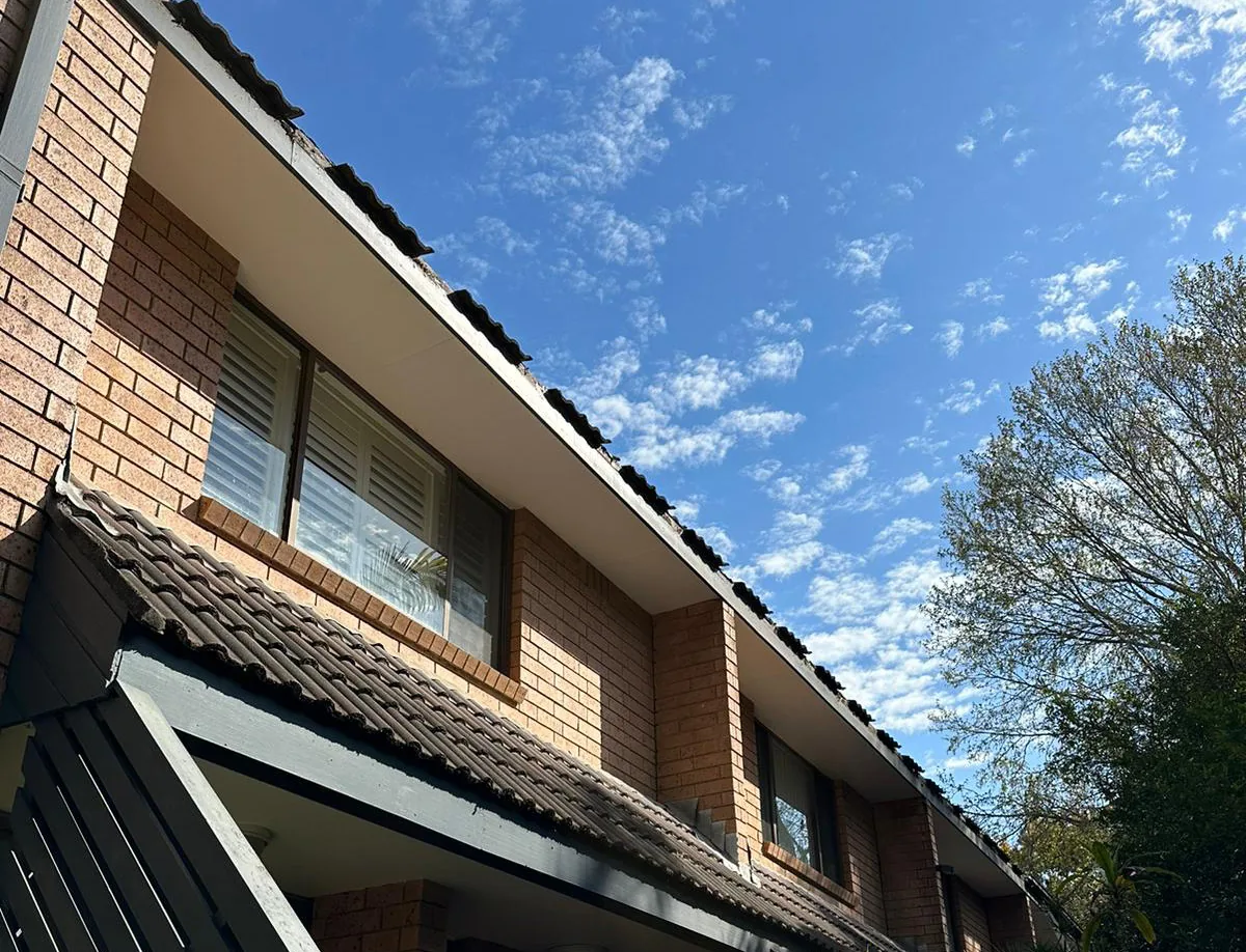 Completed dark guttering along the roofline of a two-storey brick Sydney home